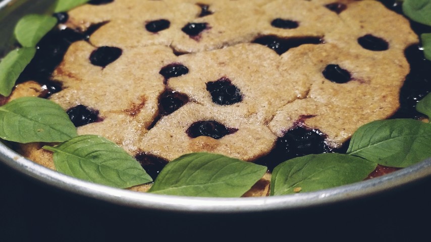 A pan with Linzer torte decorated with basil leaves on the perimeter